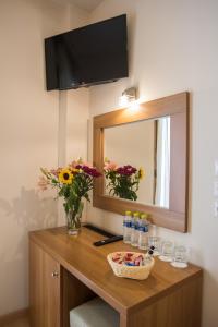 a vanity with a mirror and flowers and water bottles at THOLOS HOTEL in Delfoi