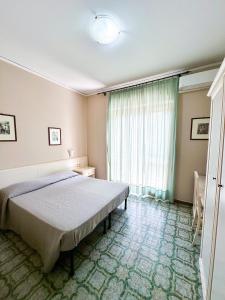 a bedroom with a bed and a large window at Hotel Europa in Pontecagnano