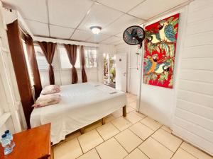 1 dormitorio con 1 cama y reloj en la pared en HOTEL BACKPACKERS RIO DULCE, en Río Dulce