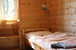 a bedroom with a bed in a wooden wall at Cottage Tatry Wellness in Tatranska Strba