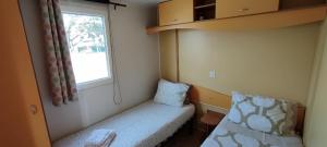 een kleine kamer met een bed en een raam bij Quinta das pedras 53 C marconi in Vendas Novas