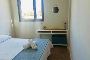 a bedroom with a bed and a desk with a towel at Habitación con baño privado para una sola persona No se renta apartamento completo in Palma de Mallorca