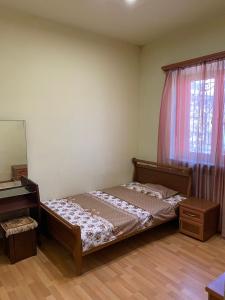 ein Schlafzimmer mit einem Bett, einer Kommode und einem Fenster in der Unterkunft Holiday house with pool in Vagharshapat