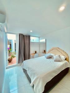 a bedroom with a bed and a large window at Casa Jardin in Cartagena de Indias