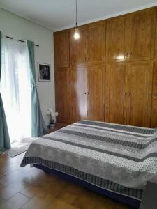 a bedroom with a large bed with wooden cabinets at Andros Escape Chora in Andros