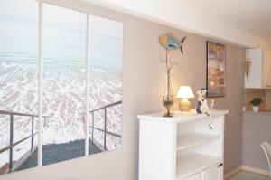 a room with a window with a view of the ocean at Le 33 Cour Normande - Appartement 2 chambres - 2 à 4 personnes - coeur Cabourg in Cabourg