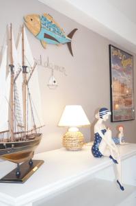 a model ship on a shelf with a lamp at Le 33 Cour Normande - Appartement 2 chambres - 2 à 4 personnes - coeur Cabourg in Cabourg