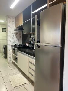 a kitchen with a stainless steel refrigerator at Luxor Ponta Verde Temporada Apartamento inteiro com 2quartos com 2 banheiros na Praia da Ponta Verde prox tudo in Maceió