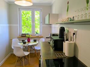 cocina con mesa y mesa pequeña con sillas en Lokal 40 - apartament w samym centrum, en Rymanów-Zdrój