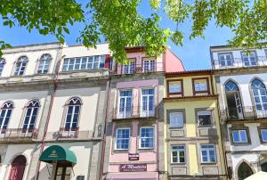 une rangée de bâtiments colorés dans une rue dans l'établissement Sé Apartamento - Casa do Chafariz, à Braga