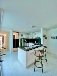 a kitchen with a counter and two chairs in it at Casa Jardin in Cartagena de Indias