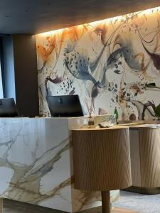 un ufficio con parete in marmo e scrivania di Hotel Bigio a San Pellegrino Terme