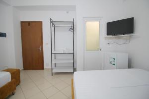 um quarto com uma cama e uma televisão na parede em Lengu Holidays Houses em Saranda