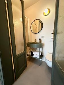 bagno con lavandino, specchio e servizi igienici di Cà Bèla - Certosa SUITES a Milano