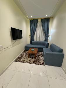 a living room with a couch and a tv at أجنحة دارنـــــا للـــشقق الــمــفــروشــة in Abha