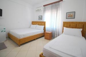 um quarto com 2 camas e uma janela em Lengu Holidays Houses em Saranda