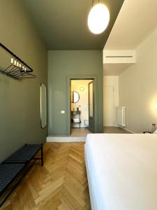 una camera da letto con un grande letto bianco e un tavolo di Cà Bèla - Certosa SUITES a Milano