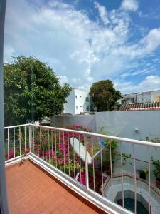 balcón con barandilla blanca y flores rosas en Casa Jardin, en Cartagena de Indias