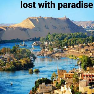 un fiume con edifici e una montagna sullo sfondo di Private transportation a Aswan