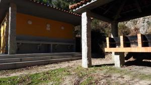 a building with a group of seats in front of it at Ermida Gerês Camping in Ermida