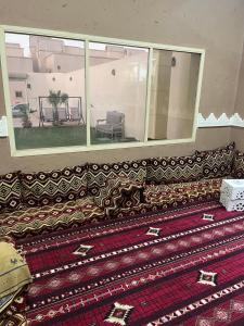 un sofá sentado en una habitación con una alfombra en شليه en Hafr Al Batin