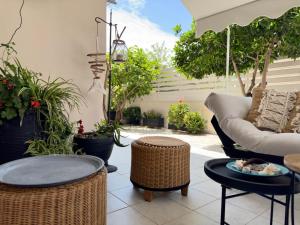 un patio con divano, tavoli e piante di Petite Fleur a Preveza