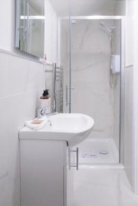 a white bathroom with a sink and a shower at The Cottage in Naas