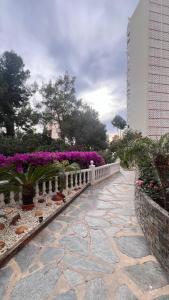 a stone walkway with flowers and a fence at Apartamento Pedro in Benidorm