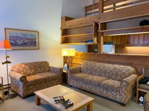Jackson Hole Vacation Condominiums في ويلسون: غرفة معيشة مع أريكة وكرسي