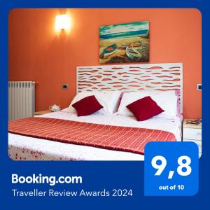 una camera con un letto con due cuscini rossi di Monolocale in Centro Tuttialmare Castellammare del Golfo Sicilia a Castellammare del Golfo