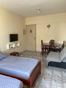a room with two beds and a table with a television at Família Pereira in São Vicente