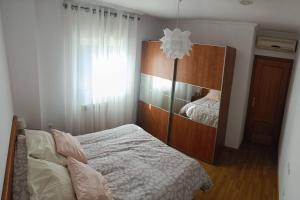 een slaapkamer met een bed en een houten kast bij Apartamento con terraza 2 hab. in Alcalá la Real