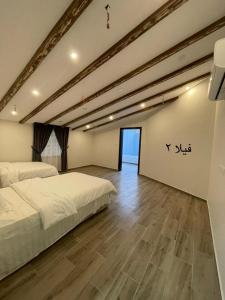 a bedroom with two beds and a wooden floor at Moonlight in Taif