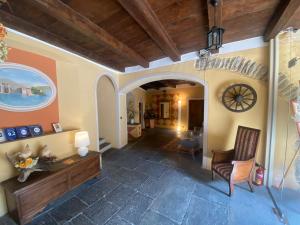 soggiorno con sedia e orologio sul muro di Hotel Casa Arizzoli a Cannobio