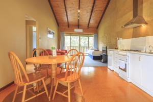 a kitchen and dining room with a table and chairs at The Koorabup Motel in Denmark