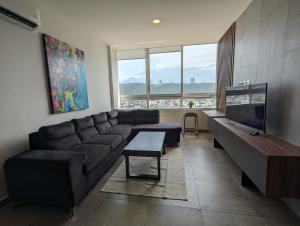 a living room with a couch and a large window at Stylish Panoramic Views City Loft in Monterrey