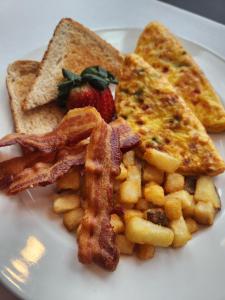 um prato de comida de pequeno-almoço com bacon, waffles e torradas em Holiday Inn Cape Cod-Falmouth, an IHG Hotel em Falmouth