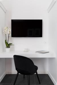 ナポリにあるEpoca Suites Napoliのデスク(椅子付)、壁掛けテレビ