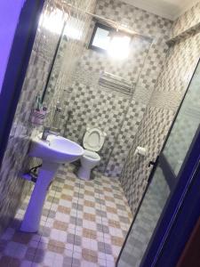 La salle de bains est pourvue d'un lavabo et de toilettes. dans l'établissement Mbazi Hotel, à Tanga