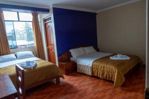 a hotel room with two beds and a window at Hotel California in Chachapoyas