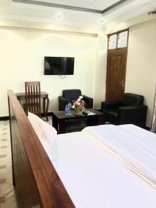 坦噶的住宿－Mbazi Hotel，酒店客房带一张床、椅子和电视