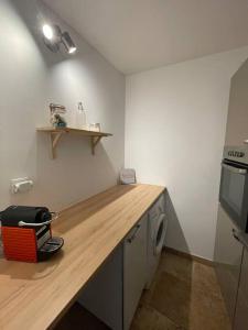 eine Küche mit einer Holzarbeitsplatte und einem Geschirrspüler in der Unterkunft Appartement à 10 min de St Rémy in Noves