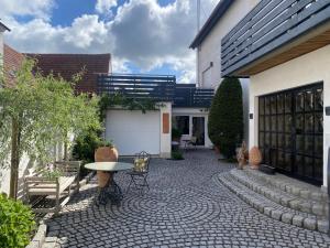 Venningen的住宿－Bienenstube，一个带桌椅的庭院和一座建筑