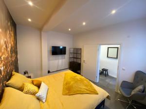 Venningen的住宿－Bienenstube，一间卧室配有一张黄色的大床和一把椅子