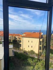 uma vista para o oceano a partir de uma janela em Suset Star II With Sea View na Calheta