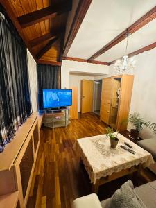 un salon avec une télévision et une table dans l'établissement Apartment Dolina 8a Kärnten KLagenfurt, 