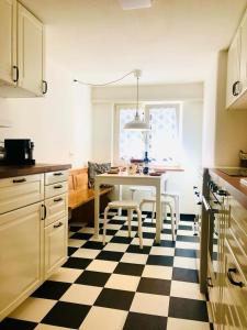 a kitchen with a table and a black and white checkered floor at Casa Via vitg sut in Schluein