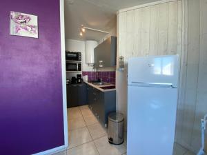 a kitchen with purple walls and a white refrigerator at L'Armazan in Saint-Lary-Soulan +2 photos