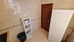 a small room with a white refrigerator and a door at Historic Malaga Centro Rooms in Málaga