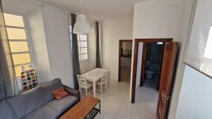 una sala de estar con un sofá y una mesa en Historic Malaga Centro Rooms, en Málaga